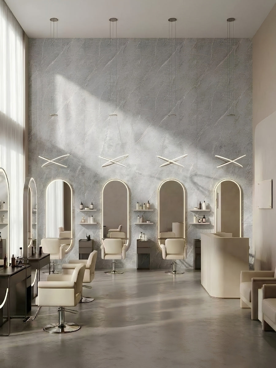 Bright salon with ash gray marble PVC wall panels behind illuminated arched styling stations