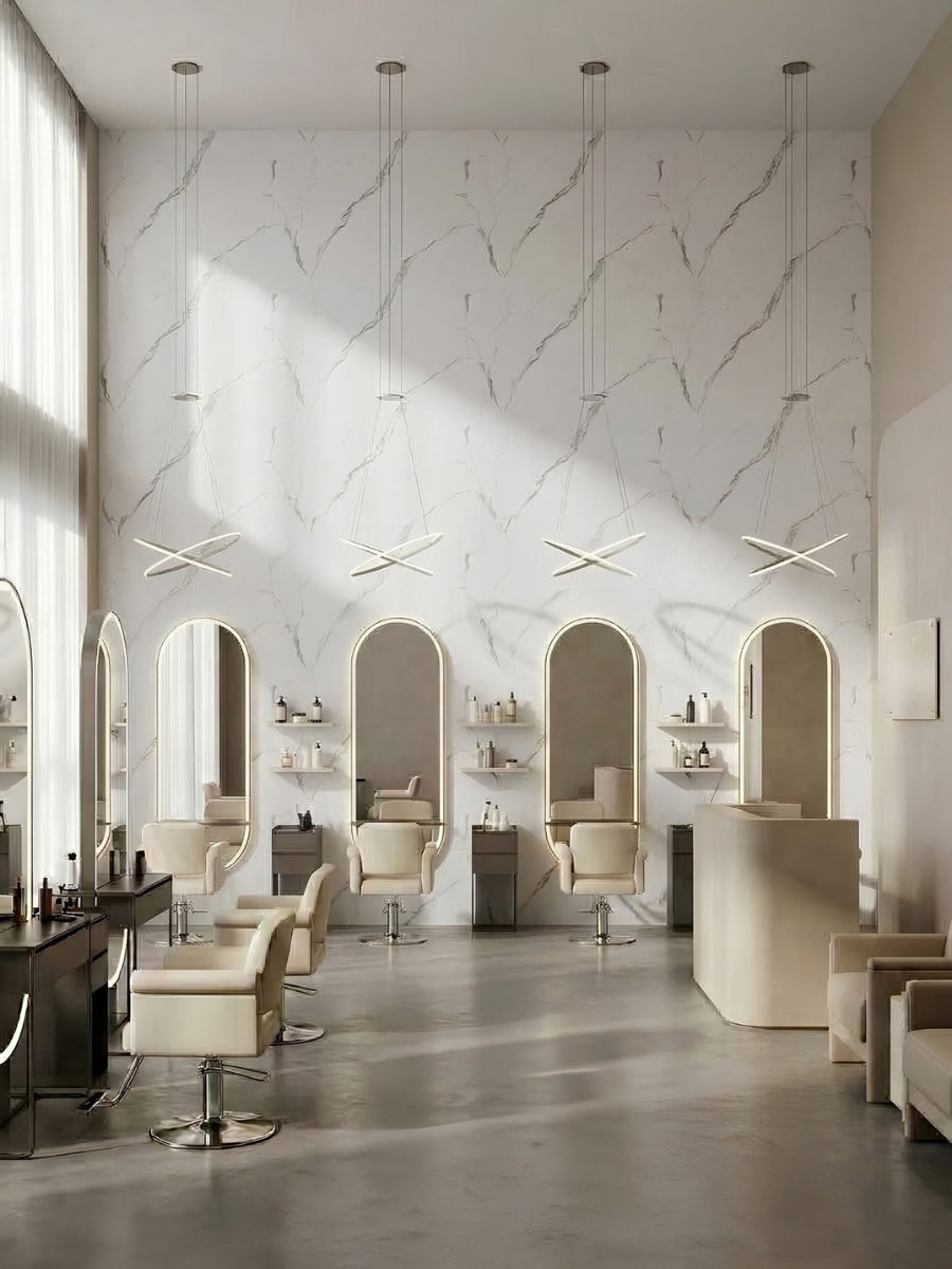Bright salon interior with styling stations set against a Calacatta Manhattan white marble-look paneled wall