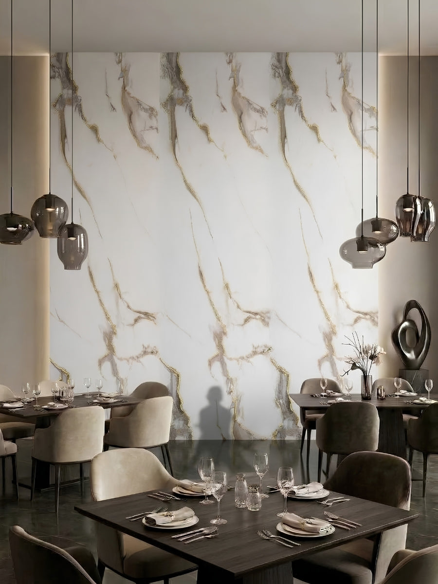 Restaurant dining area with a tall Calacatta Oro Gold Marble PVC feature wall and sculptural pendant lights