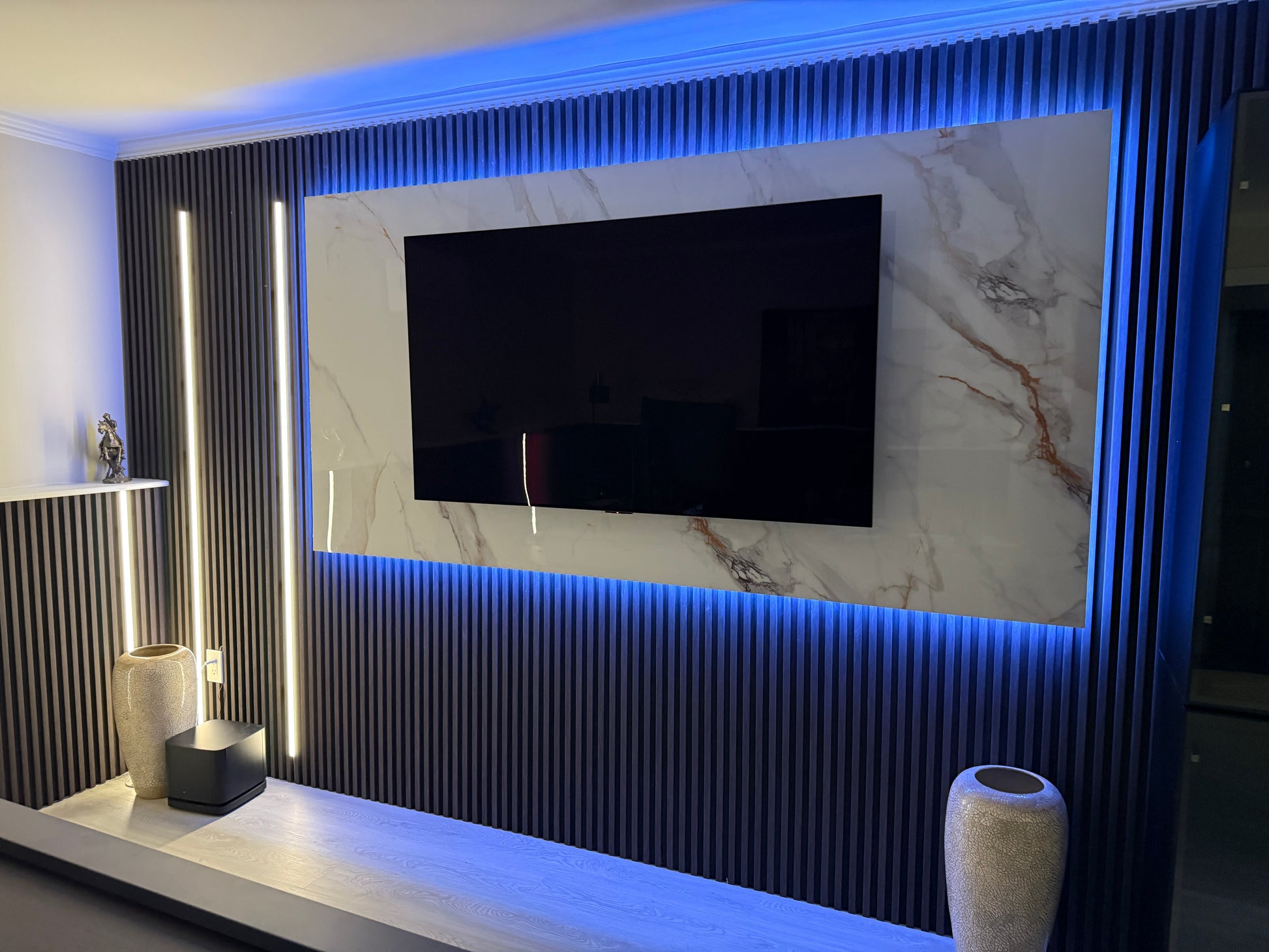Modern living room with a television mounted on a wall with decorative lighting.