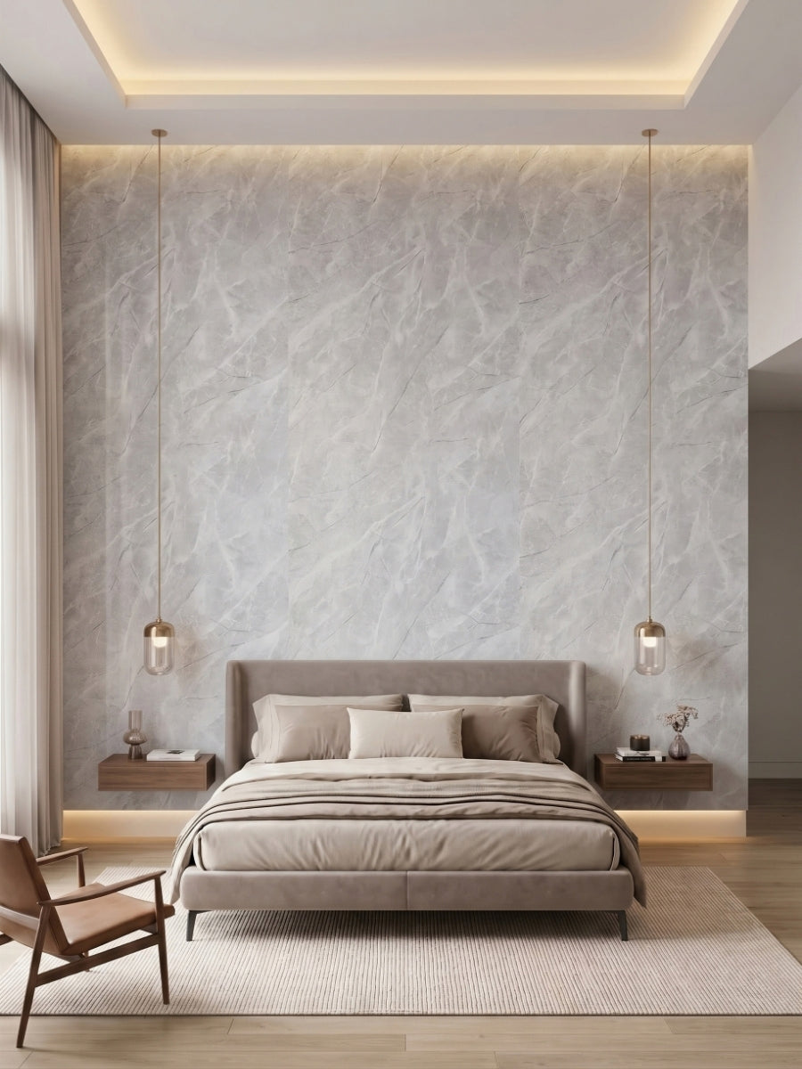 Bedroom accent wall clad in Serene Stone light gray marble-look PVC panels behind an upholstered bed