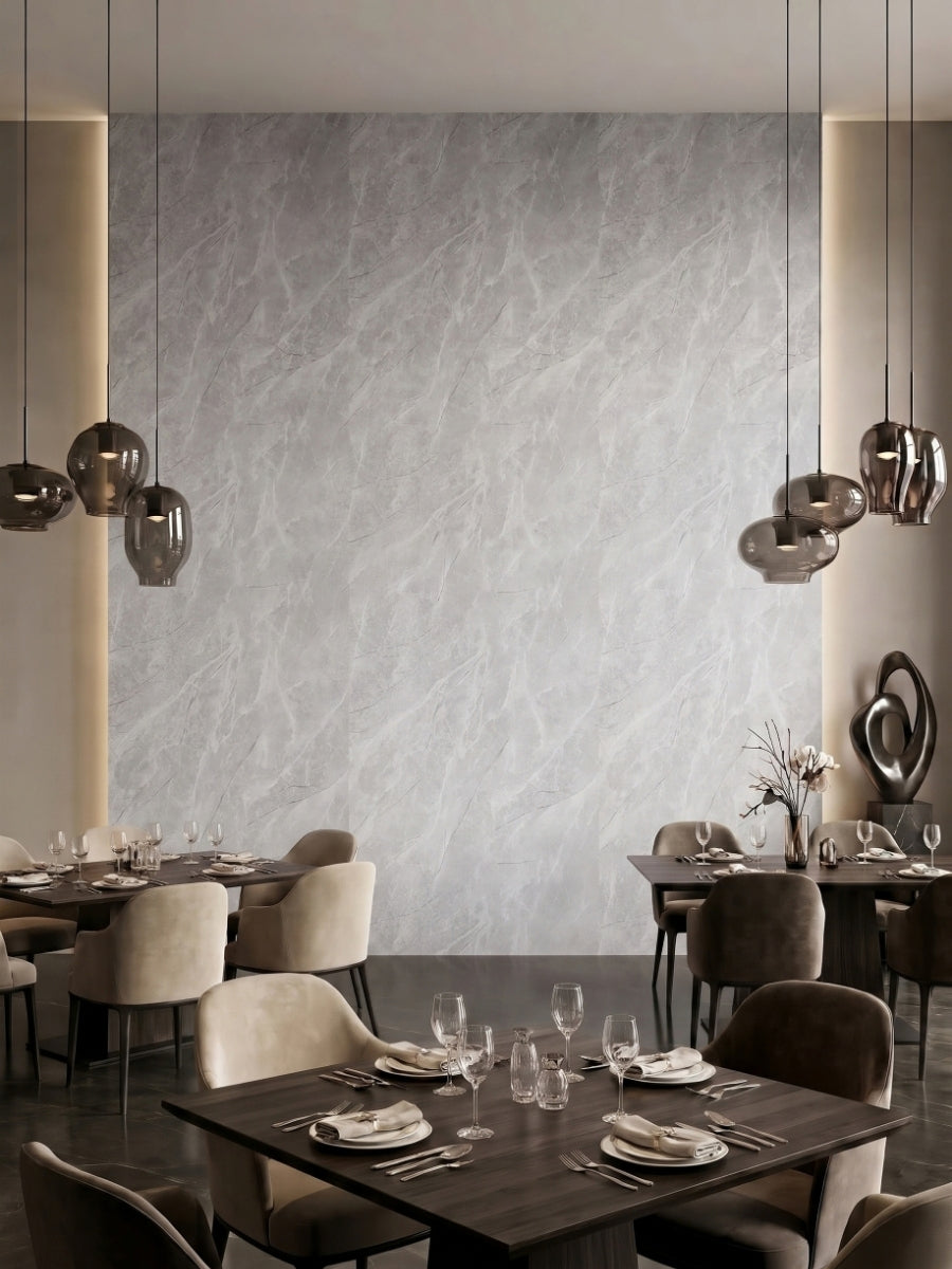 Restaurant interior featuring a Serene Stone light gray marble-look PVC panel accent wall behind dining tables