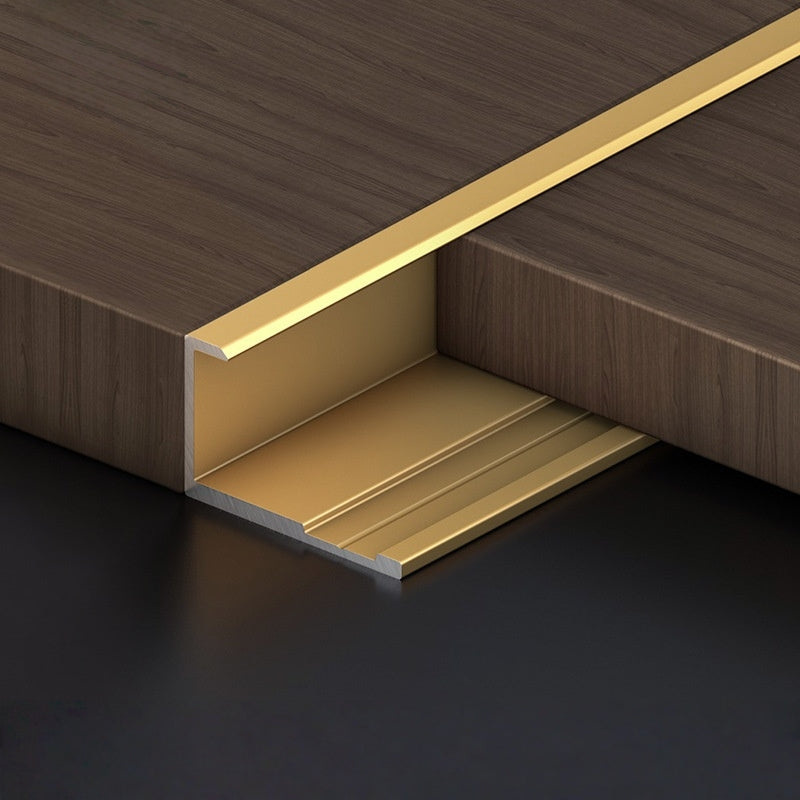 Gold aluminum wall panel trim end cap fitted between wood panels, premium metal edge strip for clean panel termination and modern interior wall design