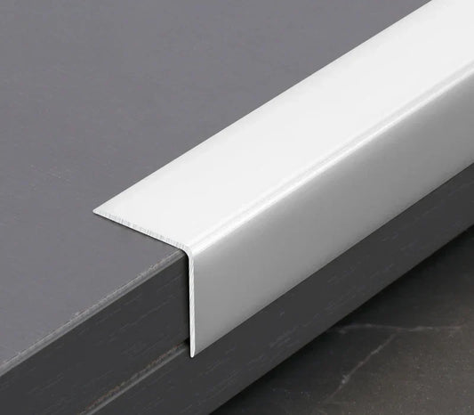 White aluminum wall panel L cap trim installed on panel edge, providing a clean finished edge and durable protection for modern interior wall panel installations